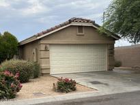 Single Gathering home featuring an attached two-car garage, desert landscaping, and a red tile roof at 7771 N 58Th Ln, Glendale, AZ 85301