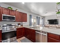 Updated kitchen boasts stainless steel appliances, granite countertops, and ample cabinet space at 8788 W Wood Dr, Peoria, AZ 85381