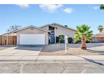 Charming single-story home featuring a two-car garage and a well-maintained, low-maintenance yard with a young palm tree at 11044 N 75Th Dr, Peoria, AZ 85345