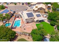 Aerial view showcasing the backyard with a pool, green lawn, solar panels, and outdoor living spaces at 1203 W Escuda Rd, Phoenix, AZ 85027