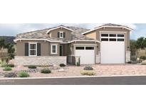 Inviting single-story home featuring a three-car garage, stone accents, desert landscaping, and a neutral color palette at 18195 W Ashley Dr, Goodyear, AZ 85338