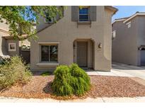 Two-story home showcasing a well-manicured front yard with decorative rock and shrubbery at 18877 E Pelican Dr, Queen Creek, AZ 85142