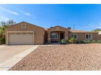 Charming home featuring a low-maintenance desert landscape, covered entryway, and an attached two-car garage at 3034 E Turney Ave, Phoenix, AZ 85016