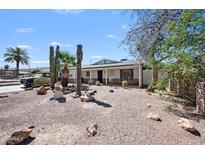 Charming single-story home featuring desert landscaping, mature trees, and a welcoming front porch at 405 W Monte Way, Phoenix, AZ 85041