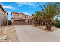 Charming home featuring desert landscaping, a spacious driveway, and a three-car garage at 44348 W Windrose Dr, Maricopa, AZ 85138