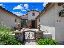 Home entrance adorned with lion statues, decorative stone, and a wrought iron gate at 683 W Honey Locust Ave, Queen Creek, AZ 85140
