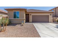 Charming home featuring a brown garage door, desert landscaping, and a cozy front porch at 17296 W Molly Ln, Surprise, AZ 85387