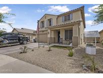 Two-story home featuring low maintenance desert landscaping, covered front porch, and attached two car garage at 17935 W Louise Dr, Surprise, AZ 85387