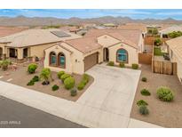 Stunning one-story home with a tile roof, arched windows, and a well-manicured front yard in a beautiful desert community at 25947 W Oraibi Dr, Buckeye, AZ 85396