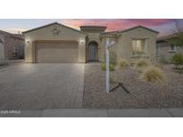 Charming single-story home with a well-manicured front yard and a brick-paved driveway leading to an attached garage at 32366 N 133Rd Ln, Peoria, AZ 85383