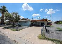 Charming single story home with a covered carport, mature landscaping, and a classic chain-link fence at 4323 W Rose Ln, Glendale, AZ 85301