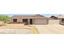 Charming single-story home featuring a well-maintained front yard and a two-car garage at 6926 W Comet Ave, Peoria, AZ 85345