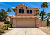 Two-story home featuring a tile roof, attached garage, and low-maintenance landscaping at 7702 W Piute Ave, Glendale, AZ 85308