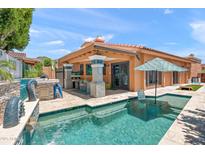 A sparkling pool with a built-in grill and patio area is perfect for entertaining at 10838 N 10Th St, Phoenix, AZ 85020