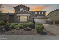 Charming two-story home with desert landscaping, a brick driveway, and a two-car garage, set against a warm sunset backdrop at 11875 W Lone Tree Trl, Peoria, AZ 85383