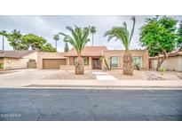 Charming single-story home with desert landscaping and a red tile roof, complemented by mature palm trees at 2329 W Keating Ave, Mesa, AZ 85202