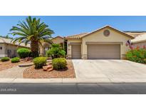 Charming home features a two-car garage and well-maintained desert landscaping, offering curb appeal at 3166 N 158Th Ave, Goodyear, AZ 85395
