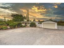 Charming single-story home with desert landscaping, separate garage, and expansive driveway at 33601 N Rifleman Rd, Cave Creek, AZ 85331