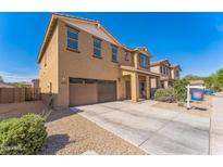 Two-story home with a brown stucco exterior, a two-car garage, and a well-maintained front yard at 45173 W Sandhill Rd, Maricopa, AZ 85139