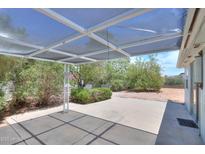 A covered patio area featuring desert landscaping and mature trees at 5228 E Des Moines St, Mesa, AZ 85205