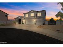 Two-story home with a three-car garage and well-maintained landscaping during a colorful sunset at 5402 S 54Th Ln, Laveen, AZ 85339