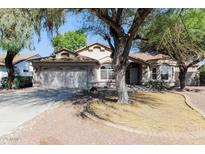 Charming single-story home with a well-manicured front yard and mature trees providing ample shade at 6126 W Paradise Ln, Glendale, AZ 85306