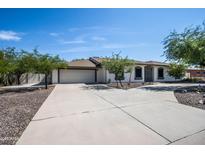 Charming single-story home with a spacious driveway and well-maintained landscaping on a clear, sunny day at 6334 E Albany St, Mesa, AZ 85205