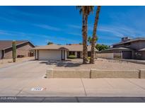 Charming single-story home featuring desert landscaping, a two-car garage, and palm trees accenting the front yard at 7940 W Willow Ave, Peoria, AZ 85381