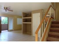 Bright living room featuring tile floors, a ceiling fan, sliding glass doors to the outside, and staircase at 151 E Broadway Rd # 210, Tempe, AZ 85282