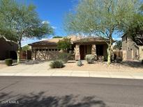 Charming single-story home featuring desert landscaping, a two-car garage, and a neutral color scheme at 26449 N 84Th Dr, Peoria, AZ 85383