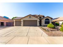 Charming home with a three car garage, tile roof, neutral colors, and desert landscaping at 4214 W Marco Polo Rd, Glendale, AZ 85308