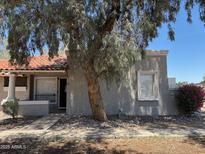 Charming single-story home features a red tile roof, stucco exterior, and mature trees in the front yard at 4820 N 89Th Ave # 88, Phoenix, AZ 85037
