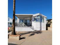 Charming single-story home featuring a covered porch with black railings and light green shutters at 1318 W Chesapeake Dr, Apache Junction, AZ 85119