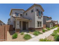 Charming two-story home features a desert landscape, covered porch, and neutral color palette at 14231 W Bronco Trl, Surprise, AZ 85387