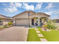 Beautiful single-story home featuring a lush lawn, a two-car garage, and a covered entryway at 15133 W Moreland St, Goodyear, AZ 85338