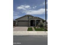 Charming single-story home featuring a well-manicured lawn and a spacious two-car garage at 15133 W Moreland St, Goodyear, AZ 85338