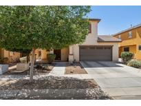 Charming two-story home featuring a two-car garage, landscaped front yard, and mature tree at 2096 S Moccasin Trl, Gilbert, AZ 85295