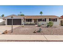 Charming single-story home featuring desert landscaping, a two-car garage, and a neutral color palette at 3010 E Yucca St, Phoenix, AZ 85028