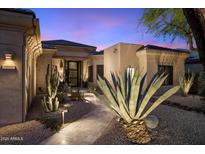 Inviting front exterior with desert landscaping and modern architectural details at twilight at 33667 N 71St Way, Scottsdale, AZ 85266
