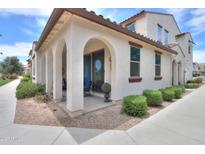 Charming stucco home featuring a covered porch with elegant archways and lush landscaping at 3855 S Mcqueen Rd # 12, Chandler, AZ 85286