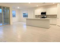 Bright open-concept kitchen features a large island, white cabinets, and stainless steel appliances at 4747 S Carver --, Mesa, AZ 85212