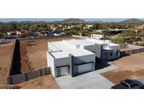 Modern home featuring a clean white exterior, a flat roof, and an extended concrete driveway at 475 W Saddle Mountain Rd, Phoenix, AZ 85086