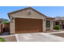 View of the exterior of the garage, showcasing the brown door and house number at 7086 W Spur Dr, Peoria, AZ 85383