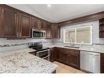 Beautiful kitchen with stainless steel appliances, granite countertops, and dark wood cabinetry at 908 W Mohawk Ln, Phoenix, AZ 85027