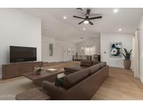 Bright living room featuring a brown sectional sofa, wood floors, and an open concept dining area at 908 W Mohawk Ln, Phoenix, AZ 85027