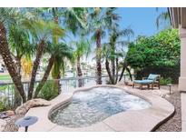 Inviting backyard with a private hot tub, waterside views and a lounge chair at 10175 E Cochise Dr, Scottsdale, AZ 85258