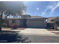 Charming single-story home with a two-car garage, desert landscaping, and well-maintained front yard at 15475 W Redfield Rd, Surprise, AZ 85379