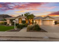 Charming single-story home with a well-manicured lawn and a three-car garage at sunset at 3102 E Desert Broom Way, Phoenix, AZ 85048