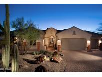 Stunning desert home with a brick driveway, lush landscaping, and a neutral color palette at 36674 N Vasari Dr, Scottsdale, AZ 85262