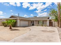 Charming single-story home with desert landscaping, a two-car garage, and a curved driveway under a partly cloudy sky at 4410 S Grandview Ave, Tempe, AZ 85282